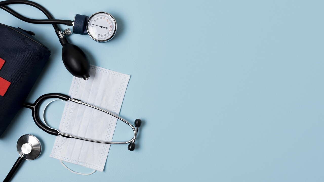 A stethoscope, blood pressure gauge, and medical mask arranged for a health examination